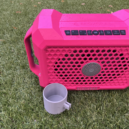 Pink ECOXGEAR Defender speaker shown with 12oz Can Holder attachment from Ruckus Marine, highlighting the clip mechanism