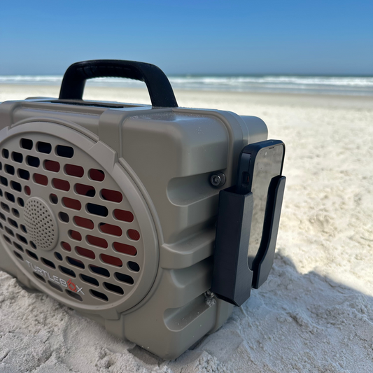Ruckus Marine phone holder for Turtlebox speakers shown in black on the beach.