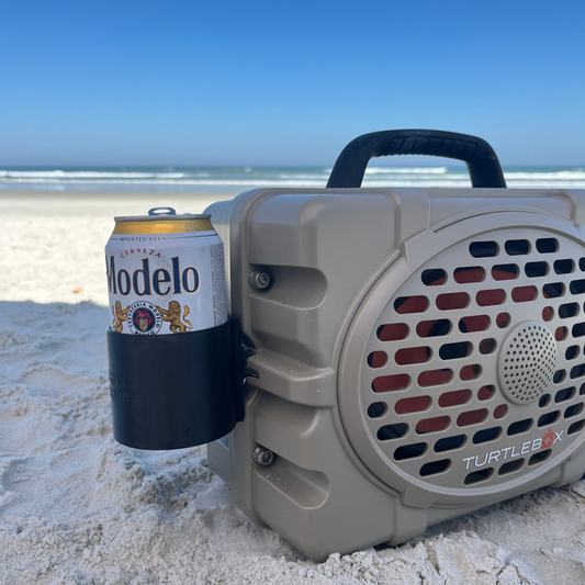 Turtlebox attachment from Ruckus Marine holding beer can on the beach.
